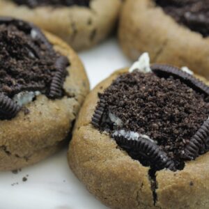 Close-up of baked cookies topped with Oreo crumble, a sweet and enticing treat.